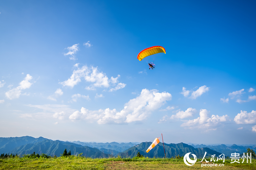 游客在野玉海飛行營(yíng)地乘動(dòng)力滑翔傘體驗(yàn)云端觀景。人民網(wǎng)記者 涂敏攝