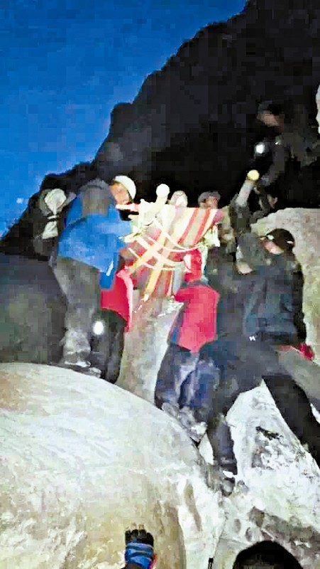 救援隊(duì)員用自制的簡(jiǎn)易擔(dān)架抬傷者。