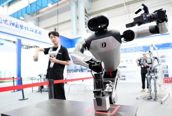 9月5日，在沈陽的2025全球工業(yè)互聯(lián)網(wǎng)大會的展覽區(qū)現(xiàn)場，中國科學院沈陽自動化研究所的機器人工程師在調(diào)試具身智能操作系統(tǒng)。新華社記者 李鋼 攝